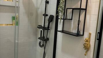 A modern bathroom with a glass-enclosed shower, a toilet, and a sink.