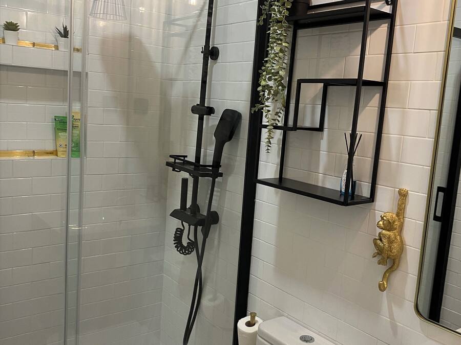 A modern bathroom with a glass-enclosed shower, a toilet, and a sink.