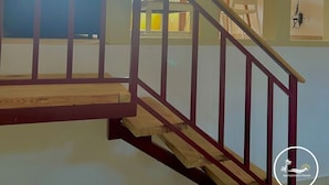 A staircase with wooden steps and a red railing leading to an upper floor. - A3 Modern apt on the Beach in Punta Cana (Punta Cana)