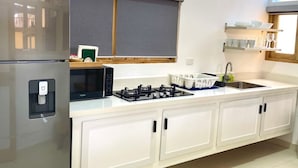 A modern kitchen with a refrigerator, microwave, stove, and cabinets. - A3 Modern apt on the Beach in Punta Cana (Punta Cana)