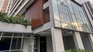 A modern high-rise building with multiple balconies, large windows, and a mix of glass and metal facade.