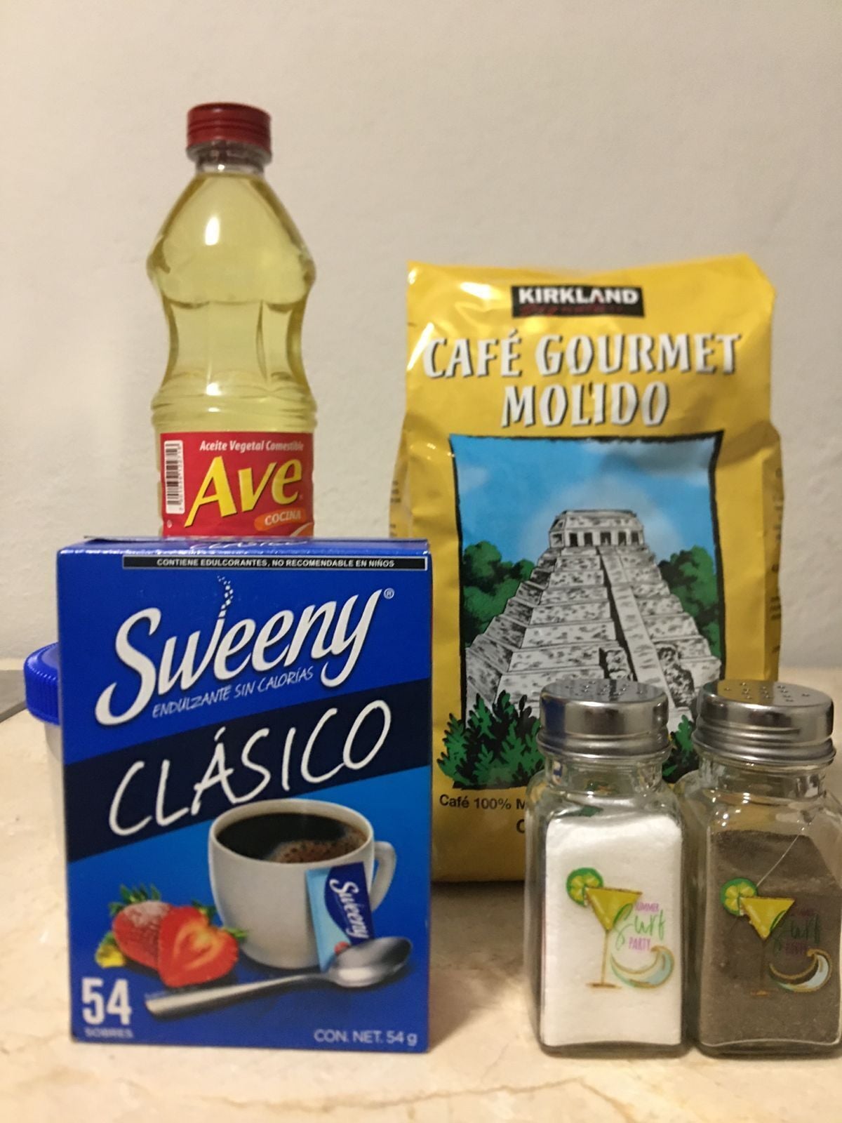 A box of Sweeney Clásico, a bottle of Ave, a bag of Kirkland Café Gourmet Molido, and two salt shakers.