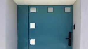 Una puerta azul con un ojo de cerradura y un timbre.