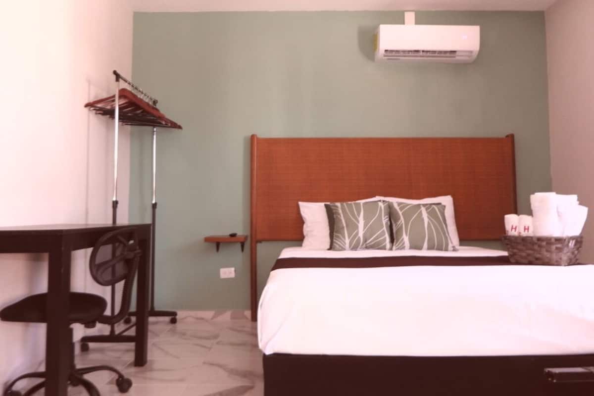 Une chambre d’hôtel équipée d’un lit, d’un bureau et d’un appareil de climatisation.