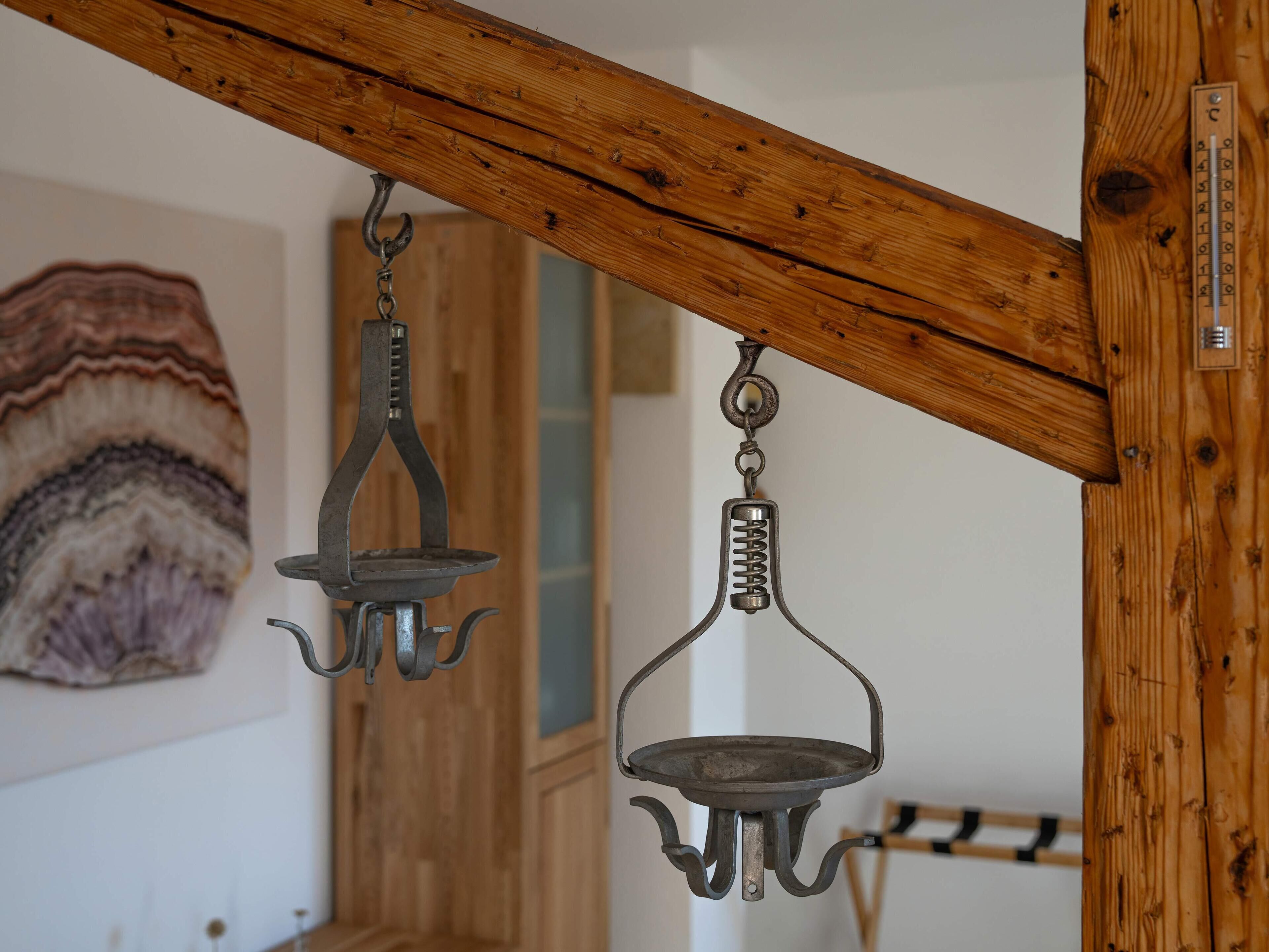 A rustic wooden ceiling with two metal chandeliers.