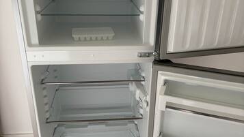 A white refrigerator with two shelves and a freezer compartment.