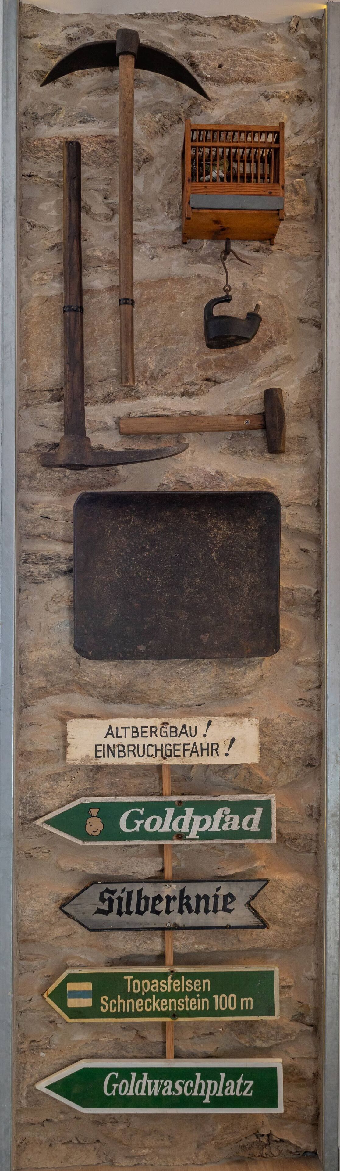 A display of old mining tools and directional signs.