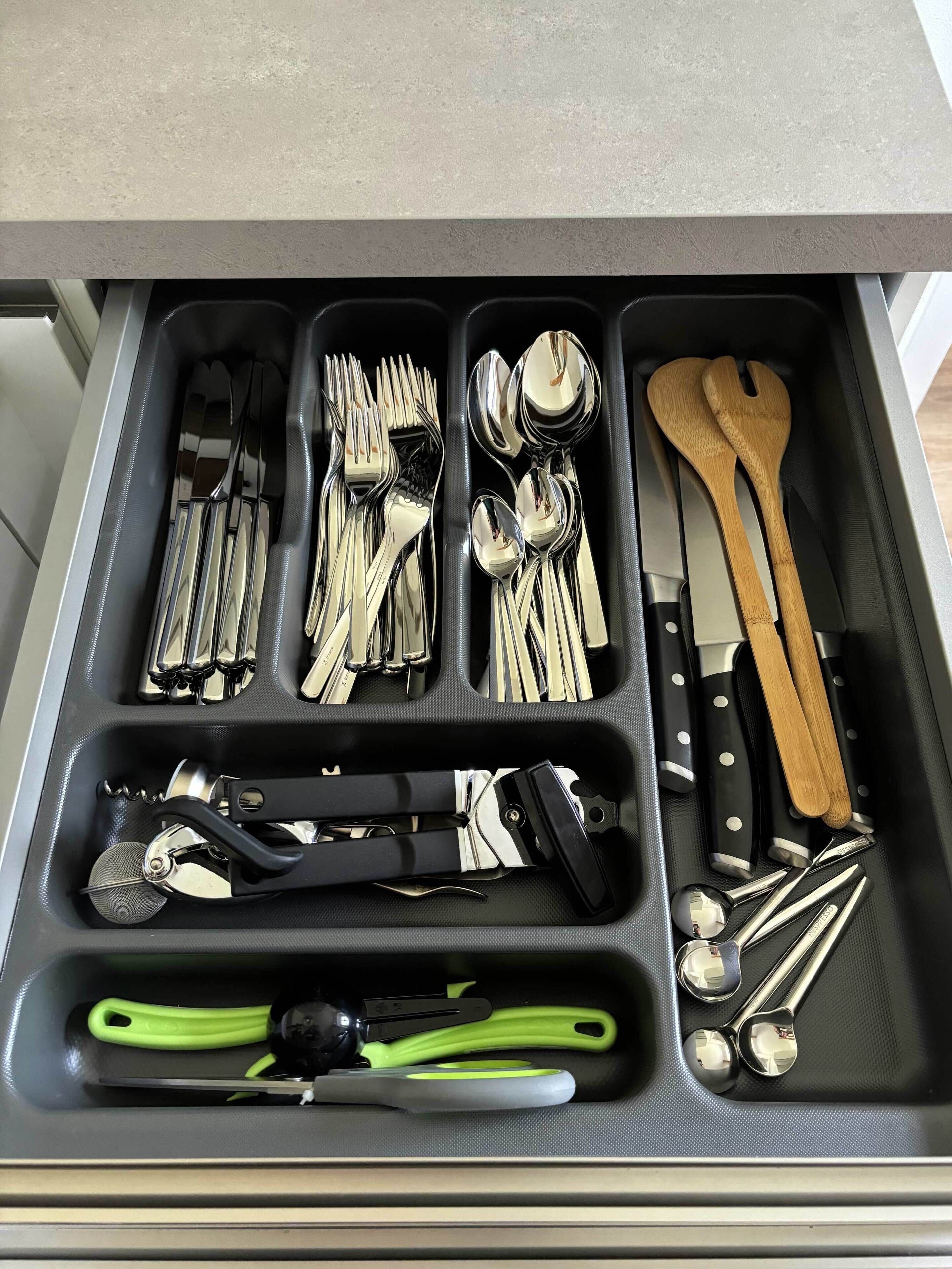 Un tiroir compartimenté contenant divers ustensiles et outils de cuisine.