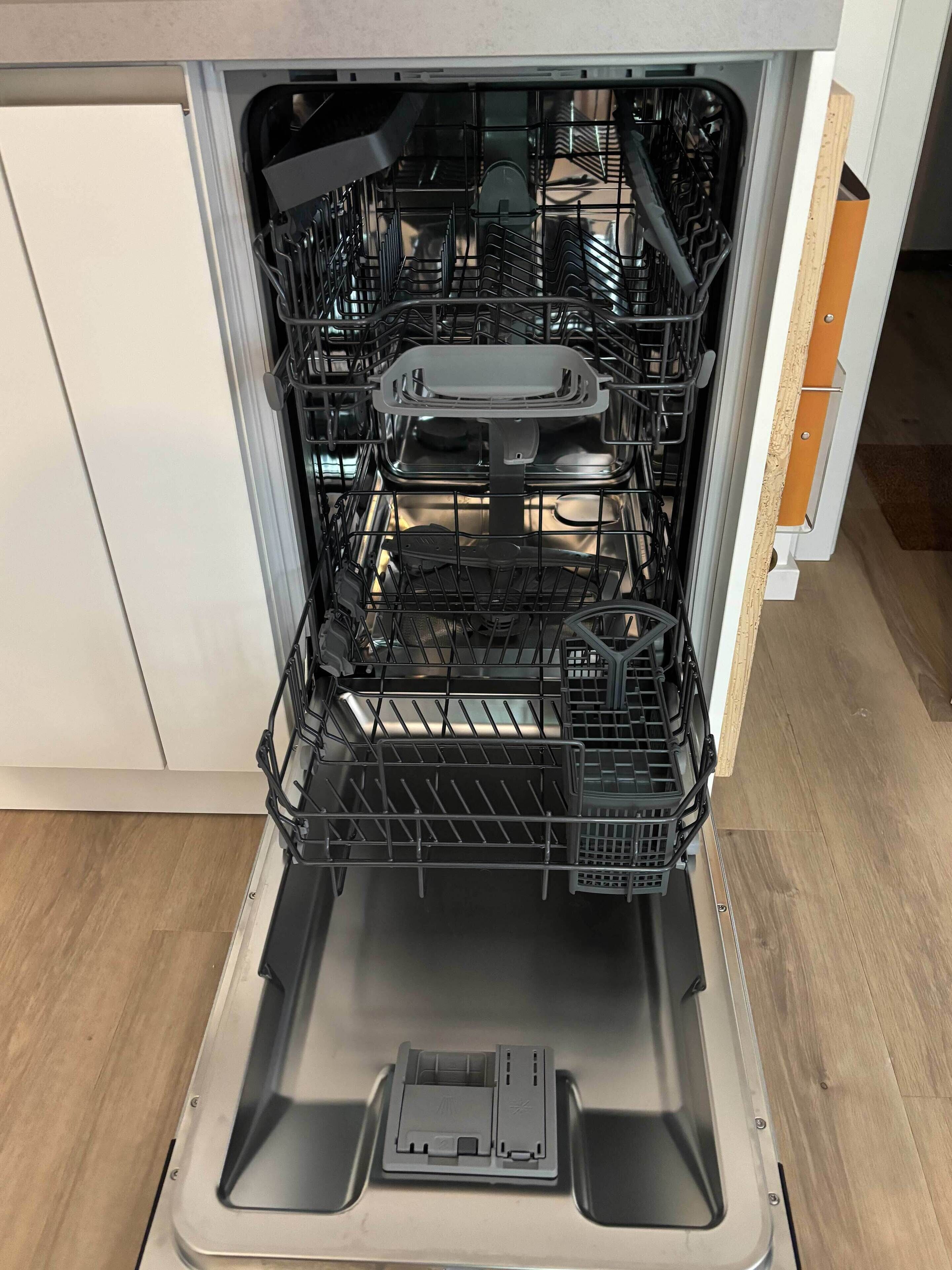 An open dishwasher with multiple racks and a control panel.