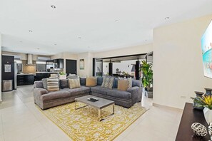 A modern living room with a sectional sofa, a coffee table, and a large window. - Secluded 4BR Villa w/ Private Pool, Santa Cruz (Santa Cruz)