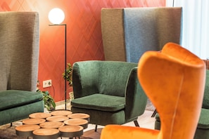 A modern living room with green sofas, a round coffee table, and a floor lamp.
