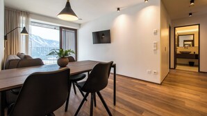Ein moderner Essbereich mit einem Holztisch, schwarzen Stühlen und einer hängenden Pendelleuchte.
