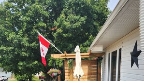 A wooden deck with outdoor furniture, a flag, and a star decoration.