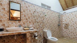 A bathroom with a sink, toilet, shower, and a mirror.