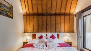 A hotel room with a bed, wooden ceiling, two bedside lamps, a window with curtains, and a painting on the wall.