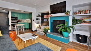 Una sala de estar moderna con chimenea, comedor y cocina.