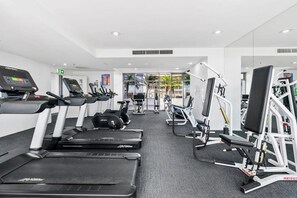 Een moderne sportschool met loopbanden, elliptische trainers en krachttoestellen.