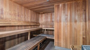 Una sauna con bancos de madera y suelo de baldosas.