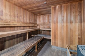 Een sauna met houten banken en een betegelde vloer.