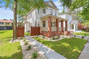 A two-story house with a front porch, a brick column, and a small front yard with a tree and a sidewalk. - Luxury Casa B
(Savannah)
