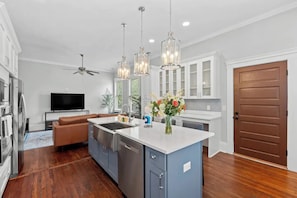 A modern kitchen with a central island, stainless steel appliances, and pendant lighting. - Luxury Casa B
(Savannah)