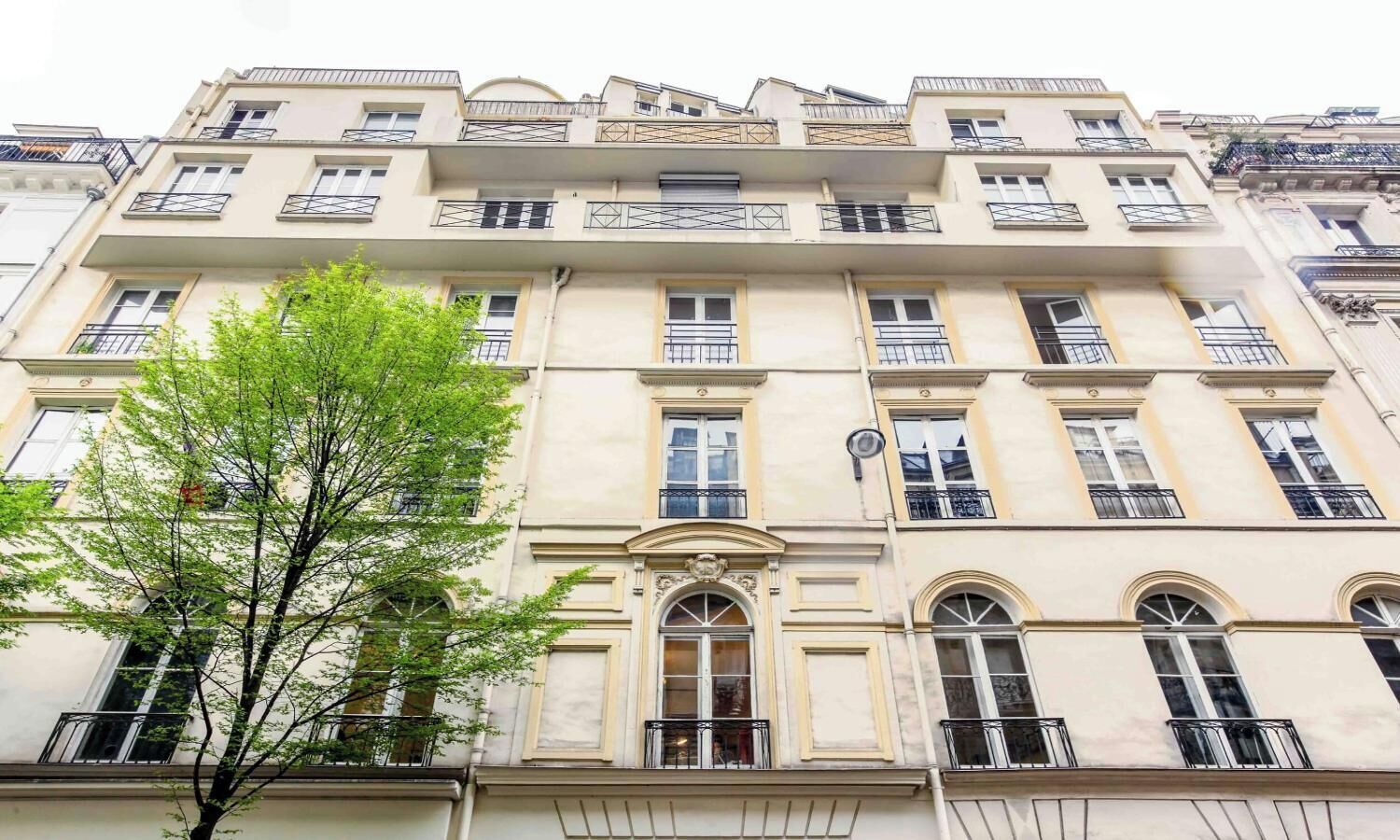 A multi-story building with a classical architectural style, featuring symmetrical windows and decorative moldings.
