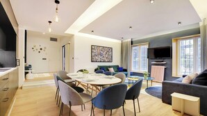 A modern living room with a dining area, a sofa, and a TV. - WHERE EVERY CORNER REVEALS A PIECE OF RICH HISTORY & VIBRANT CULTURE - LE MARAIS (Paris)