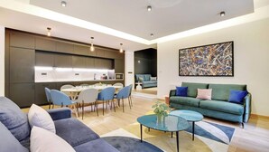 A modern living room with a sofa, coffee table, and a dining area with chairs and a table. - WHERE EVERY CORNER REVEALS A PIECE OF RICH HISTORY & VIBRANT CULTURE - LE MARAIS (Paris)
