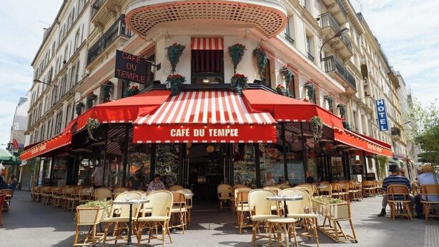 A cafe with outdoor seating and a red awning. - WHERE EVERY CORNER REVEALS A PIECE OF RICH HISTORY & VIBRANT CULTURE - LE MARAIS (Paris)