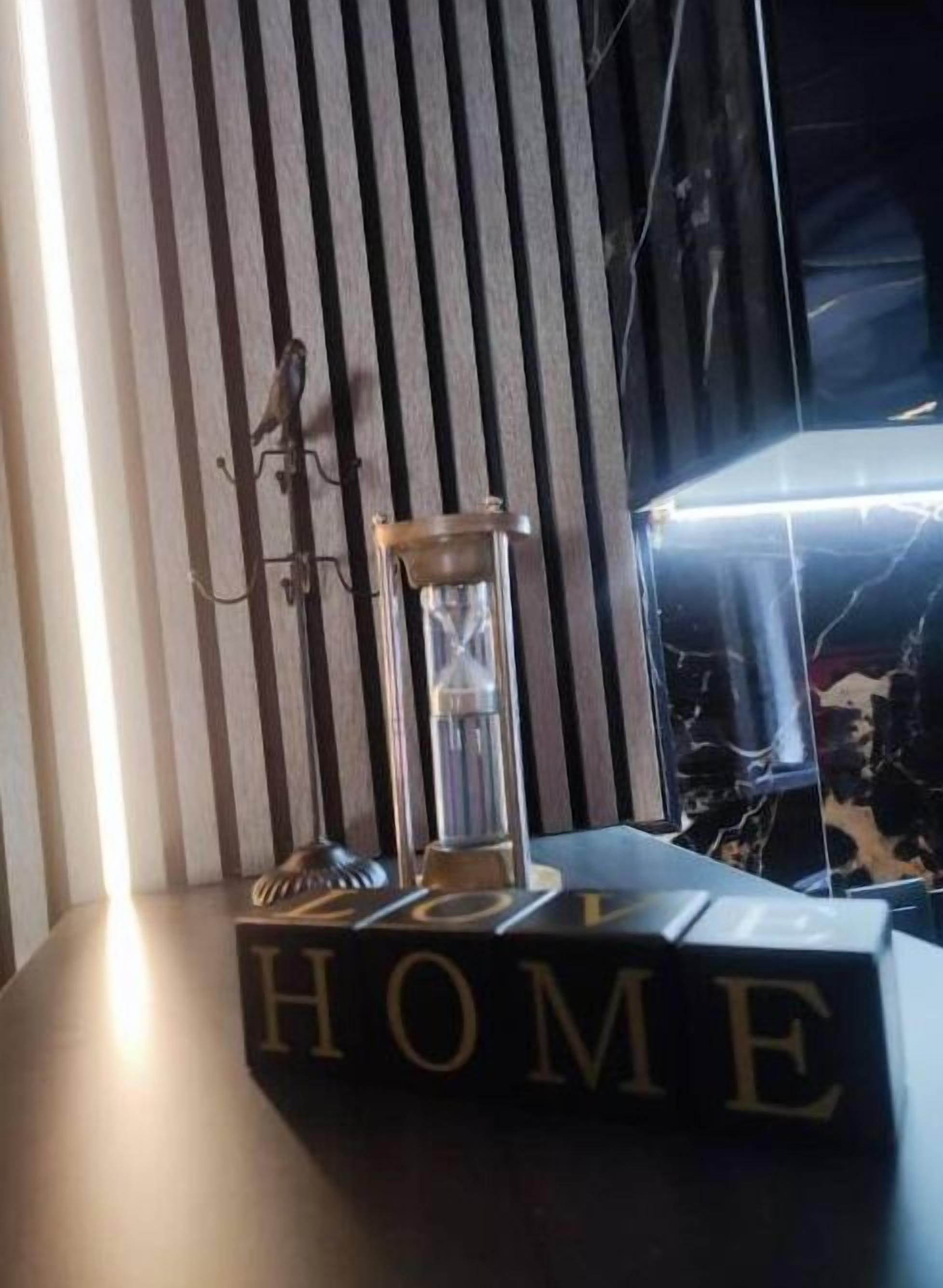 A room with a bed, a bedside table, and a lamp.
