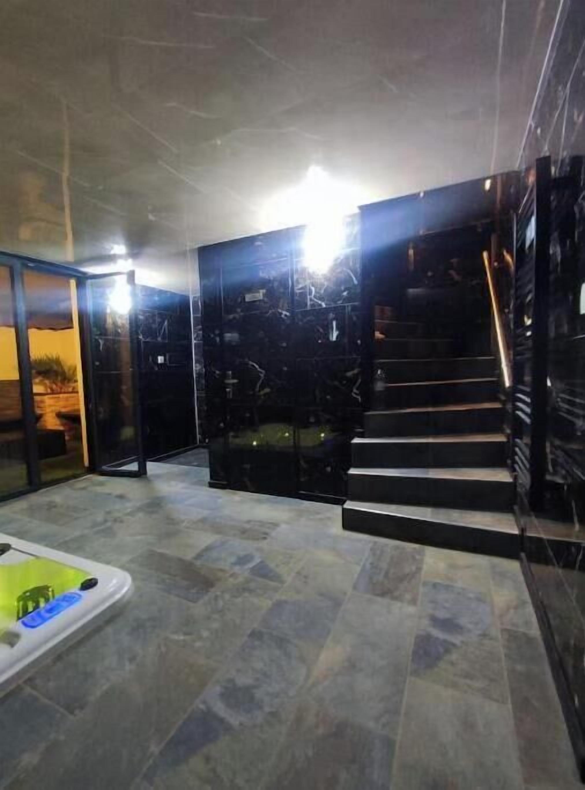 Een modern interieur met een glazen deur naar een patio, een klein zwembad en een trap.