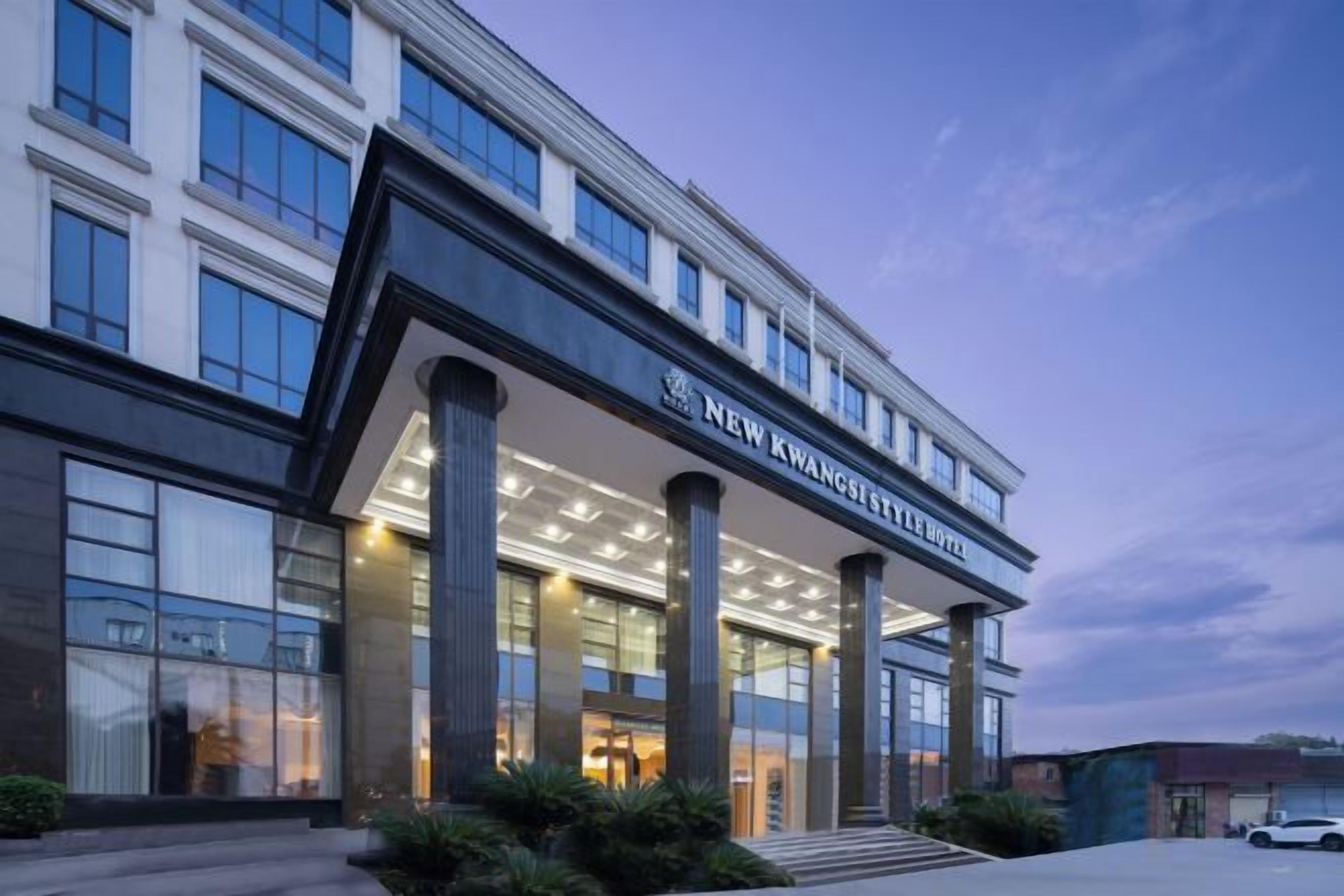 Um hotel com fachada moderna, colunas imponentes e entrada destacada.