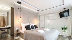 A modern bedroom with a large bed, bedside tables, a desk, and a TV. -  ApartPark by Baltic Home (Swinoujscie)