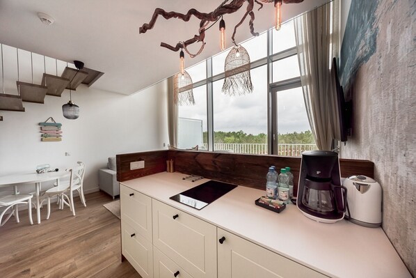 A modern kitchen with a large window, a coffee maker, and a sink.