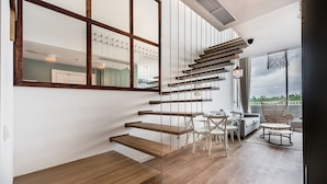 A modern interior with a wooden staircase leading to a balcony. -  ApartPark by Baltic Home (Swinoujscie)