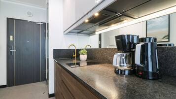 A modern kitchen with a built-in stove, a coffee maker, and a sink.