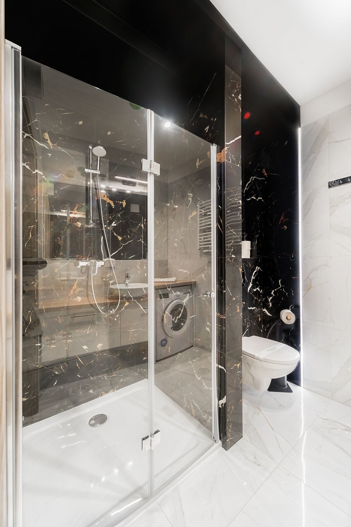 Un baño moderno con ducha envuelta en vidrio, inodoro y lavamanos.