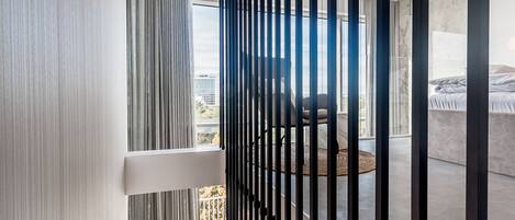 Una escalera moderna con escalones de madera y barandilla de metal negro.