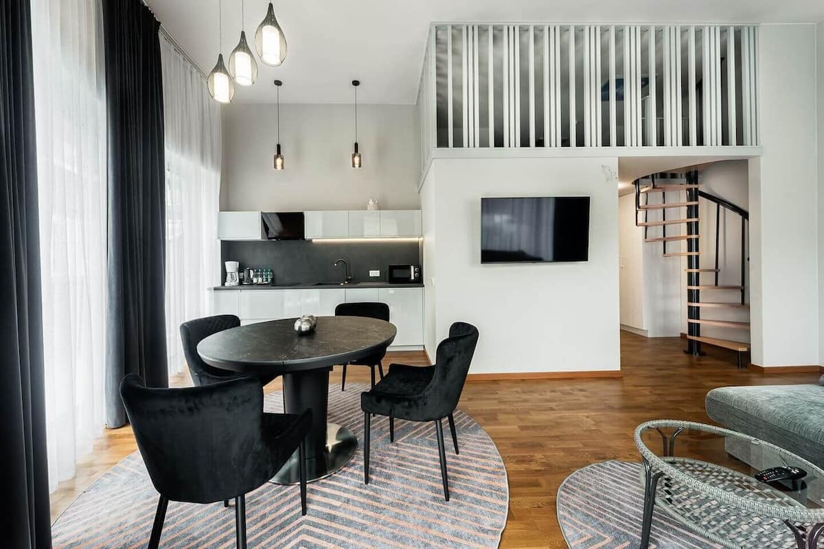Ein modernes Wohnzimmer mit Essbereich, Treppe und Küche.