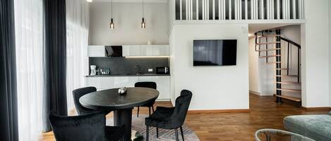 Uma sala de estar moderna com área de jantar, escada e cozinha.