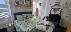 A bedroom with a bed, a dresser, a mirror, and a window with blinds. - The Hideaway/cottage Feel/patio/central/parking (Southport)