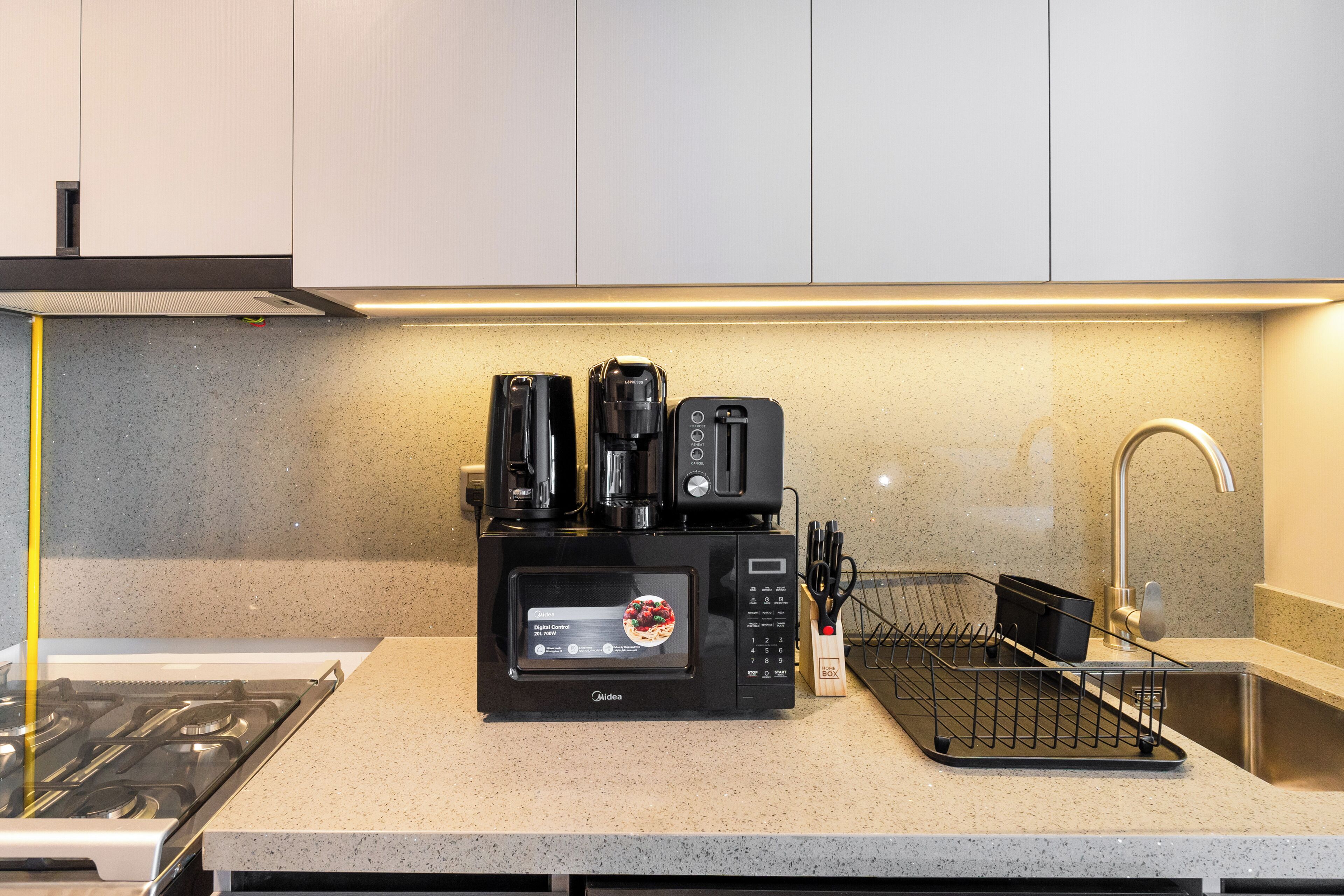 Eine Küche mit Einbau-Mikrowelle, Kaffeemaschine und Toaster.