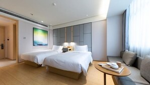 A hotel room with two beds, a sofa, a small table, and a painting on the wall. - JI Hotel (Wenling Wanchang Road Subway Station) (Wenling)