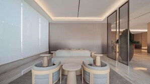 A modern lounge area with a sofa and round tables, a glass partition, and a large window. - JI Hotel (Wenling Wanchang Road Subway Station) (Wenling)
