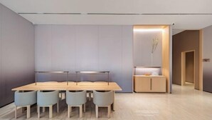 A modern dining area with a long table and six chairs, a small cabinet with a plant, and a door leading to another room. - JI Hotel (Wenling Wanchang Road Subway Station) (Wenling)
