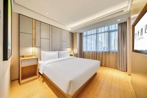 A hotel room with a large bed, a nightstand, a wall-mounted TV, and a window with curtains. - JI Hotel (Wenling Wanchang Road Subway Station) (Wenling)