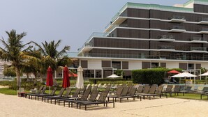 Een modern hotel met een zwembadgedeelte, compleet met ligbedden en parasols.