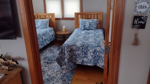 Un dormitorio con dos camas, una mesita redonda y un televisor.