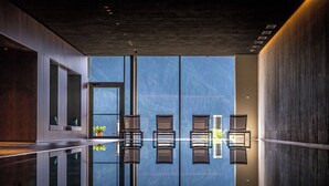 Un intérieur moderne avec un revêtement de sol réfléchissant, un espace salon et une vue sur l’extérieur.