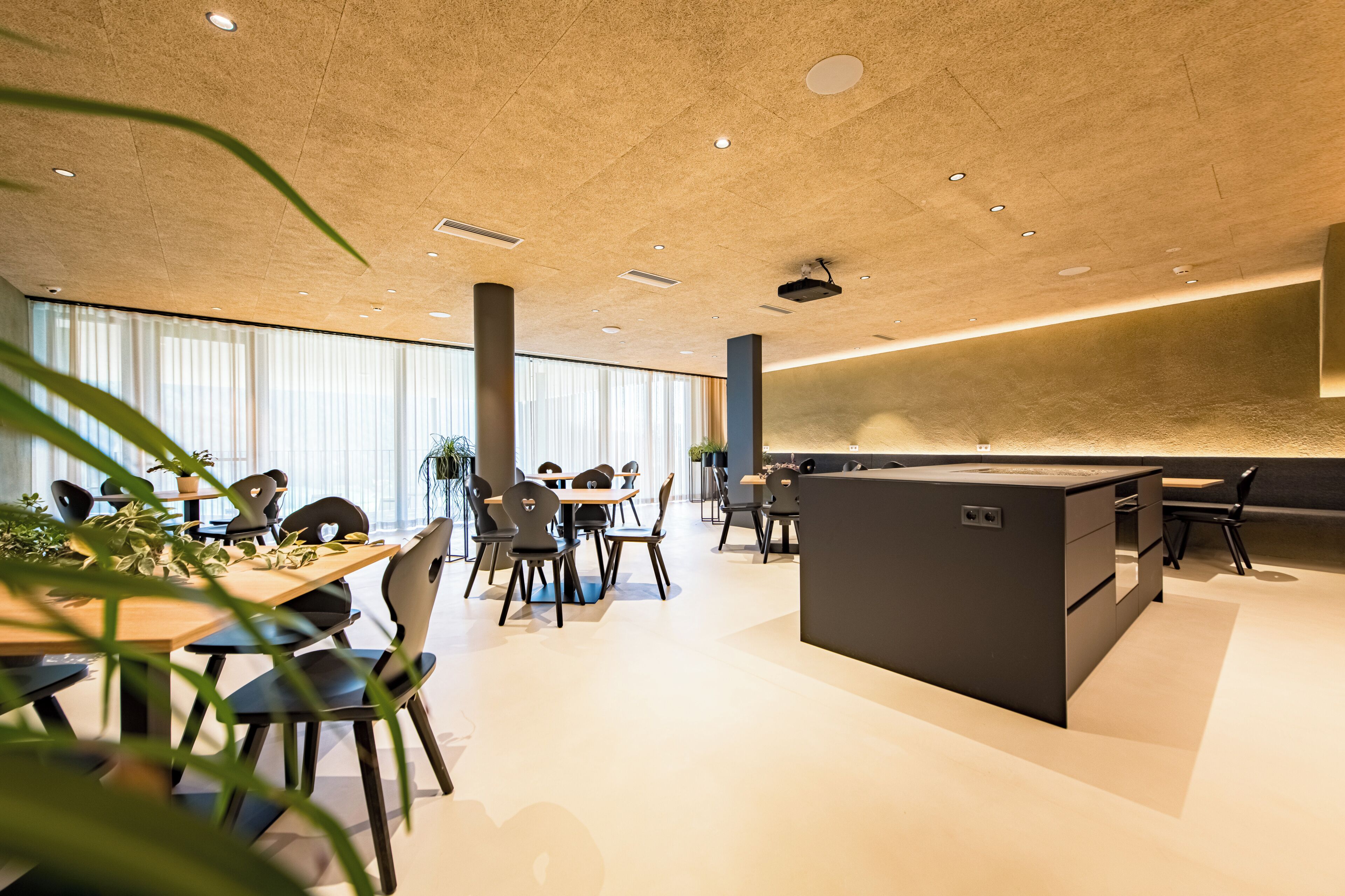 Un espace de bureau moderne doté d’un îlot central, de tables rondes et de chaises.